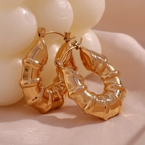 Macro detail of 18K gold plated hoop earrings with textured bamboo tire design