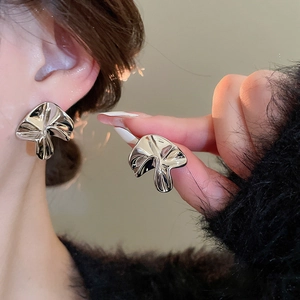 Detailed view of silver irregular pleated mushroom stud earrings with mirror finish