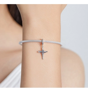 Detailed close-up of a vintage S925 silver mesh bracelet with rose cross pendant on wrist