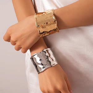 Polished gold and silver wide textured metal bangles with artistic wavy edges for women