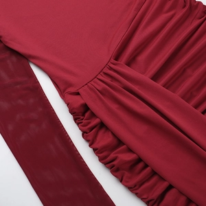 Detail of elegant burgundy dress featuring ruched knit fabric and sheer mesh splicing