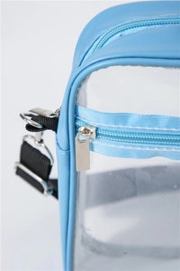 Close-up of light blue PVC crossbody bag showing silver zipper and metal hook details