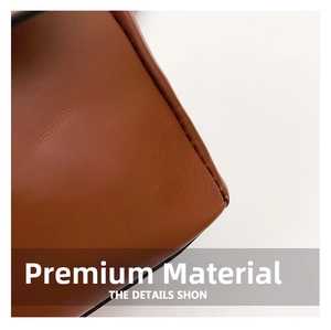 Close-up of premium brown leather texture with detailed stitching on a small square bag