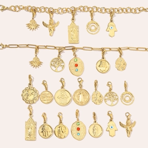 Golden titanium steel tree of life and hamsa hand charms on a soft pink background