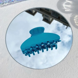 Detailed blue Y2K acetate hair claw clip reflecting sky and clouds on a mirror surface