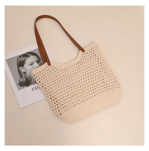 Detail of beige hollow-out woven cotton shoulder bag with thin brown straps
