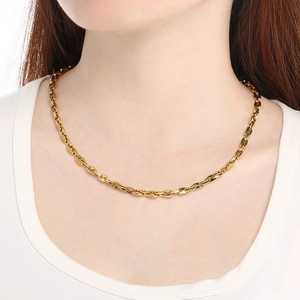 Gros plan d'un collier chaîne d'ancre doré porté par un mannequin sur fond blanc