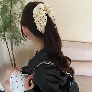 Close-up of a polka dot cloud bubble banana clip used for a ponytail on a model