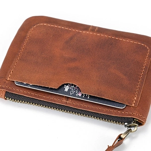 Close-up of vintage brown leather coin purse showing zipper detail and card slot texture