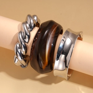 Three-piece set of silver metallic and brown tortoiseshell resin bangles on a model arm