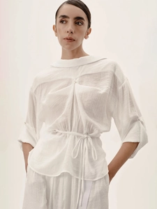 Set camicia a pieghe bianca con cintura in vita e pantaloni coordinati donna