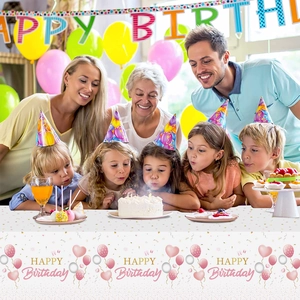 Detail of happy birthday tablecloth with pink balloons and hearts in a family party setting