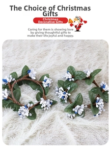 Detail of Christmas candle ring with white berries, green leaves and rustic vine base