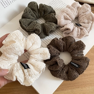 Detailed close-up of knitted scrunchies with wavy textures in earth tone colors