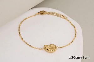 Détail du bracelet doré avec pendentif conque et chaîne de 20 cm avec extension