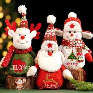 Close-up of knitted Christmas gift bags with Santa, Snowman and Reindeer characters