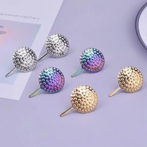 Detailed macro view of textured circular 304 stainless steel stud earring bases in varied finishes