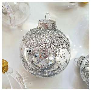 Macro shot of a clear Christmas ornament ball filled with shiny silver hexagonal sequins