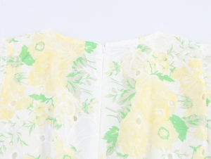 Macro shot of white eyelet fabric with yellow floral print and invisible back zipper