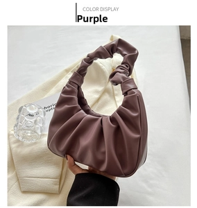 Detailed close-up of a purple pleated underarm bag with soft PU leather texture