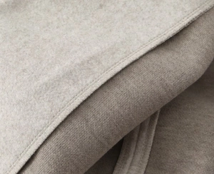 Gros plan du tissu polaire gris avoine montrant les coutures et la texture de qualité
