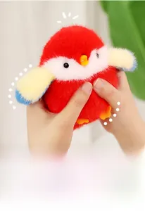 Gros plan montrant la texture douce d'un pendentif oiseau en peluche rouge pressé