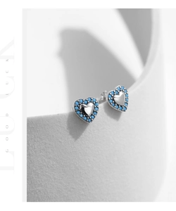 Macro shot of S925 silver heart stud earrings with turquoise beads on stone decor