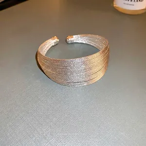 Bracciale a più strati in maglia d'argento con estremità sferiche e texture metallica