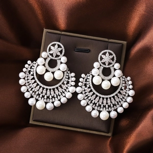Vintage pearl flower drop earrings with rhinestones and silver needle on silk background