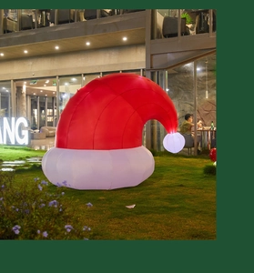 Close-up of inflatable Christmas hat decoration with internal LED lighting on lawn
