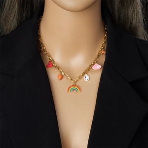 Collier doré avec breloques arc-en-ciel et cœur colorés porté par un modèle