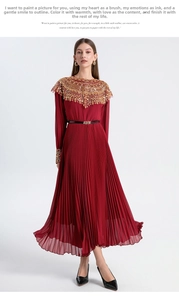 Detail of red pleated maxi dress featuring golden embroidery and sequins at the neckline