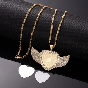 Detailed view of golden heart-shaped wing pendant with sparkling crystals and DIY insert