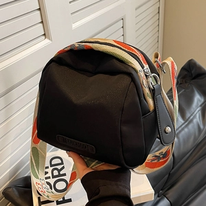 Black nylon shell bag with colorful woven wide strap and rubber logo detail