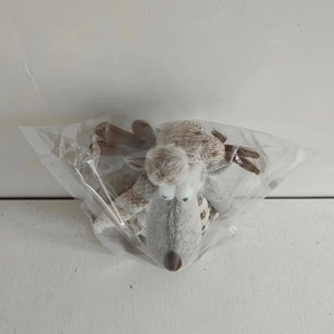Macro shot of a grey plush reindeer figurine inside a clear protective plastic bag