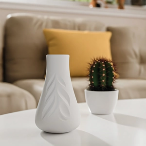 Detail of white ceramic vase with leaf relief texture in a modern living room