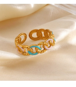 Detail of adjustable gold chain ring with blue and pink enamel on beige silk background