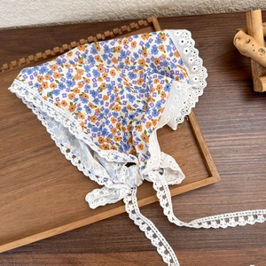 Detailed close-up of blue floral lace bandana on a rustic wooden tray for a vintage look