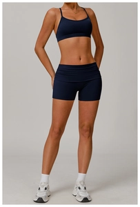 Détail du short de yoga taille haute plissé et de la brassière bleu marine