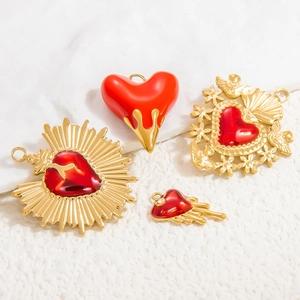 Detail of red enamel heart pendants with 18k gold plated vintage artistic designs