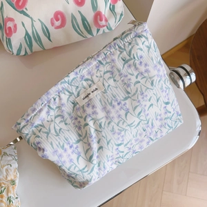 Détail d'une trousse de maquillage fleurie avec étiquette simple wish et zip en métal