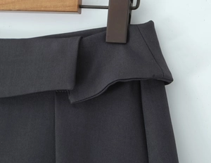Detail van donkergrijze rok met hoge taille, omslagband en twill textuur