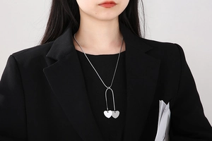 Detail of silver heart snake chain necklace worn on model for adjustable style