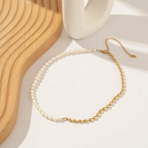 Detail of elegant dual-texture necklace with white pearls and gold metal beads