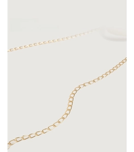 Detail of elegant gold necklace with open loop clasp on a minimalist beige backdrop