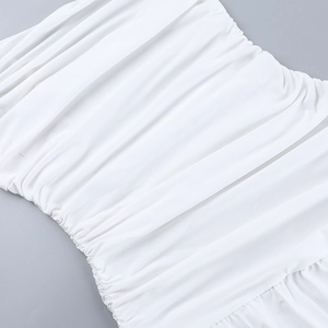 Détail de la texture froncée complexe sur le tissu blanc d'une robe longue d'été