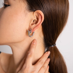 Minimalist architectural earrings in 18K gold and silver steel worn by a model