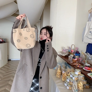 Detailed texture of corduroy fabric hand-held tote bag with smile print and snap button