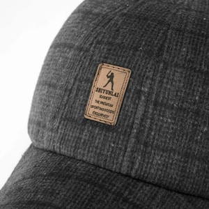 Macro shot of a charcoal wool baseball cap with a premium brown leather logo patch