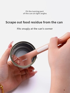 Close-up of pink silicone pet can spoon scraping the inside edge of a wet food can